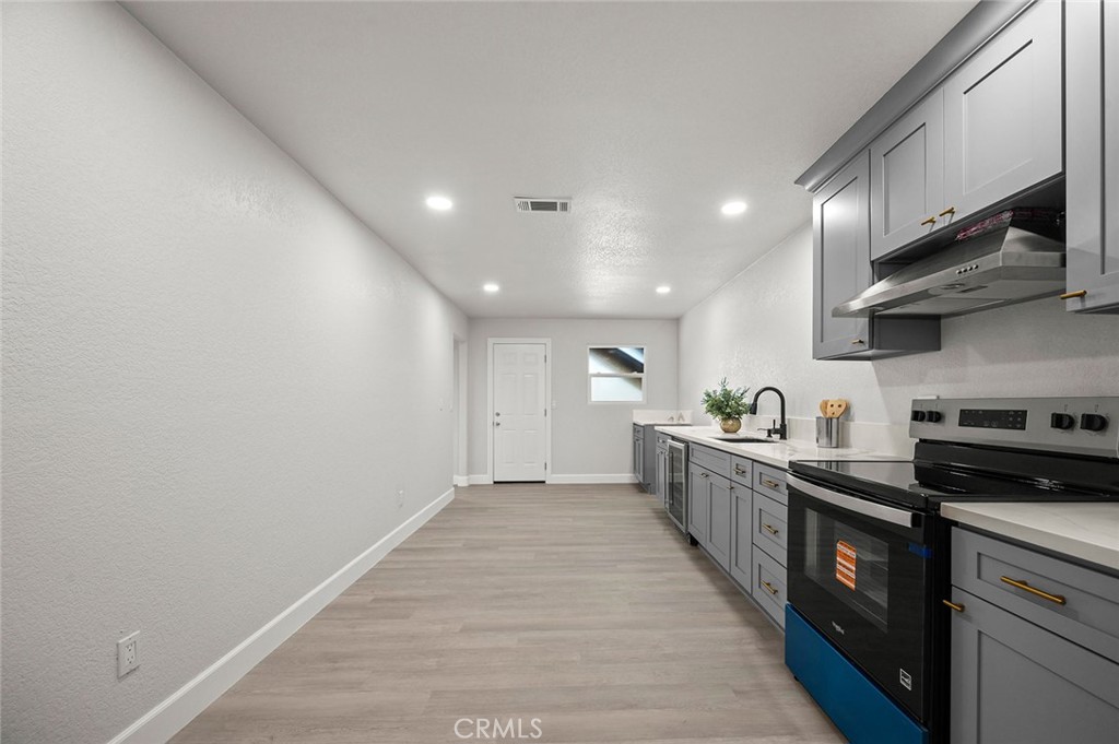 27875 Goetz Road Menifee, CA 92587 - Photo 43 of 74 a large kitchen with stainless steel appliances a sink a stove and cabinets