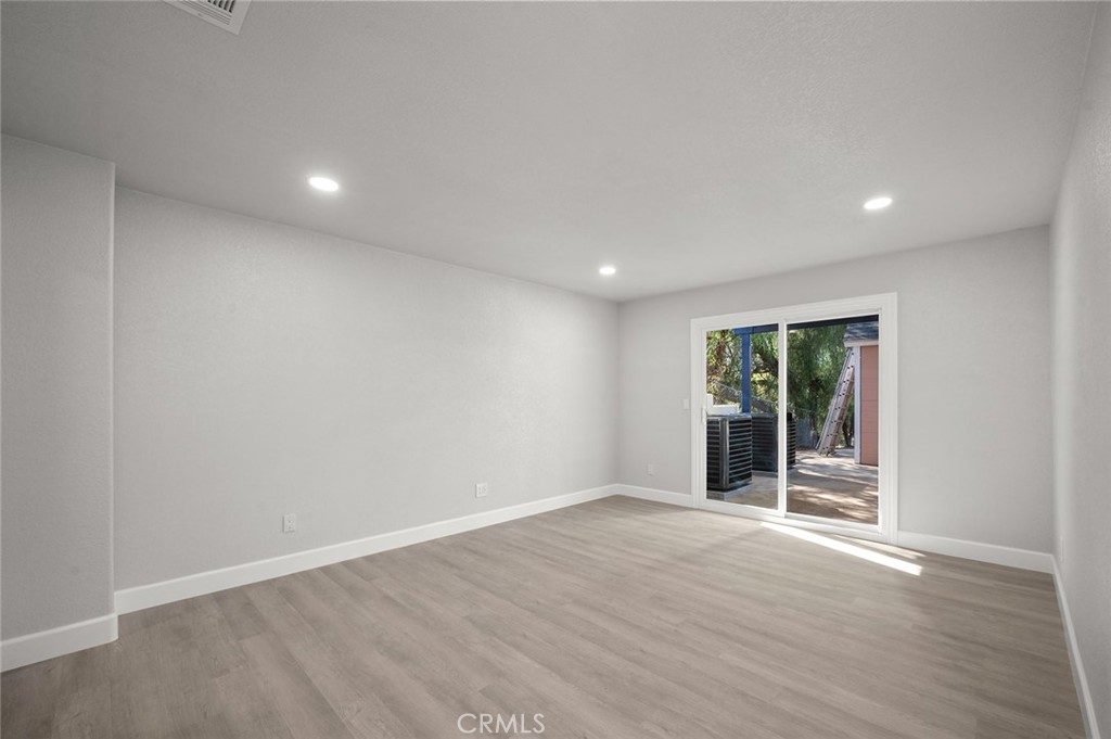 27875 Goetz Road Menifee, CA 92587 - Photo 44 of 74 an empty room with wooden floor and windows