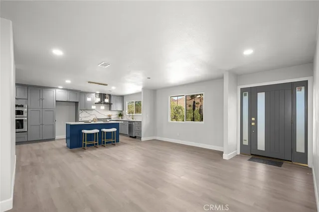 a kitchen with kitchen island granite countertop wooden floors and stainless steel appliances
