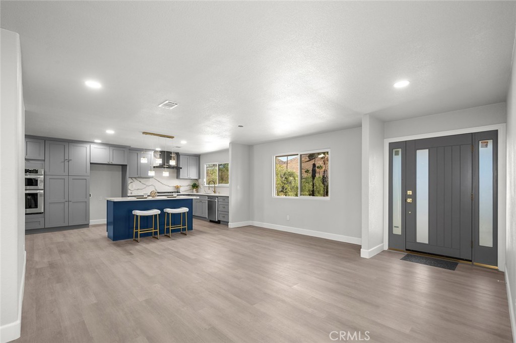 27875 Goetz Road Menifee, CA 92587 - Photo 8 of 74 an empty room with kitchen view and windows