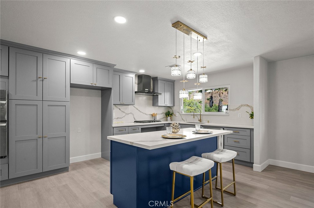 27875 Goetz Road Menifee, CA 92587 - Photo 10 of 74 a kitchen with a refrigerator a sink dishwasher a stove and a dining table with wooden floor