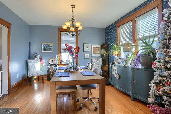 a view of a dining room with furniture a chandelier and wooden floor
