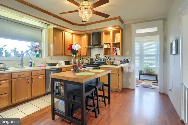 a kitchen with a sink stove and wooden floor