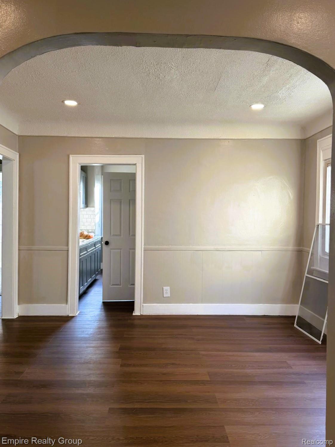 6441 Appoline Street, Unit 1 Dearborn, MI 48126 - Photo 6 of 13 Spare room featuring arched walkways, a textured ceiling, dark wood-style flooring, and recessed lighting