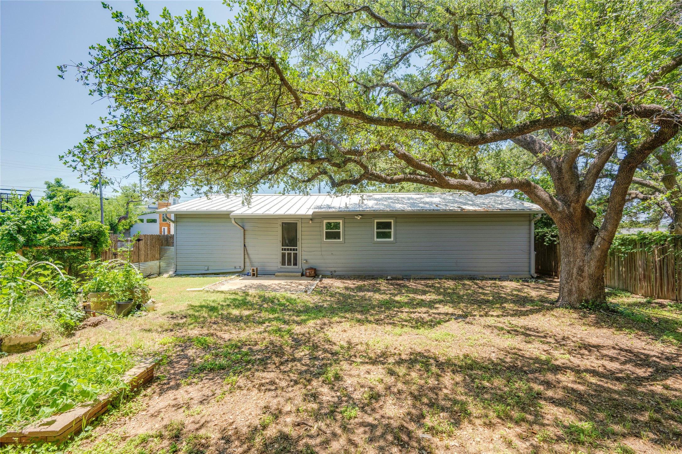 1707 Overhill Drive Austin, TX 78721 - Photo 36 of 36 A spacious backyard awaits, framed by mature trees and offering plenty of room for outdoor enjoyment.