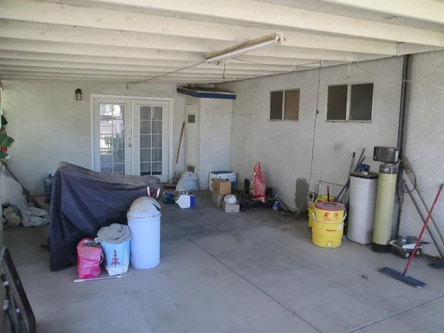 a utility room with a refrigerator and a potted plant