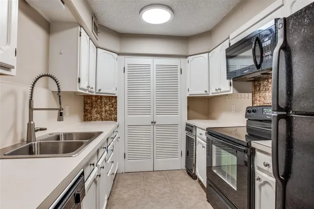 a kitchen with a sink appliances and cabinets