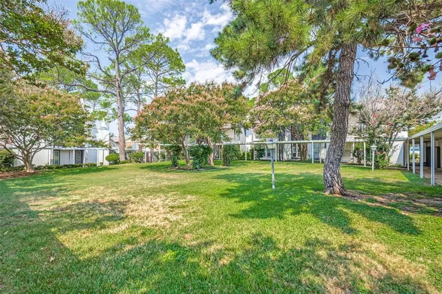 a view of a house with a big yard and large trees