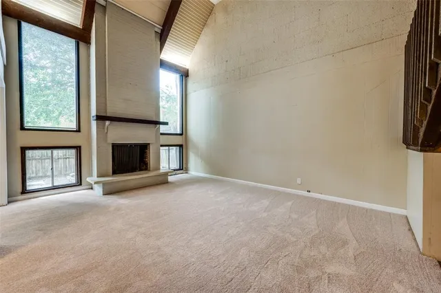 a view of empty room with fireplace and window