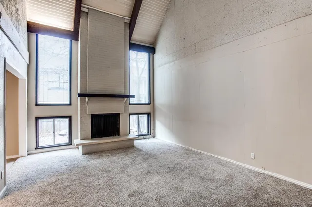a view of empty room with fireplace and window