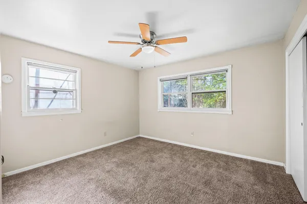 a view of a livingroom with a ceiling fan and window