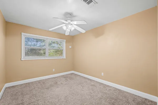 an empty room with a fan and a fan