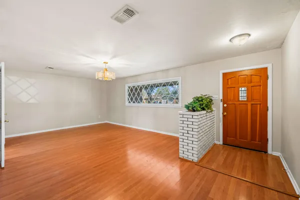 wooden floor in an empty room with a window