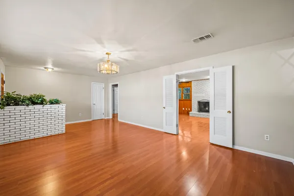 a view of empty room with wooden floor
