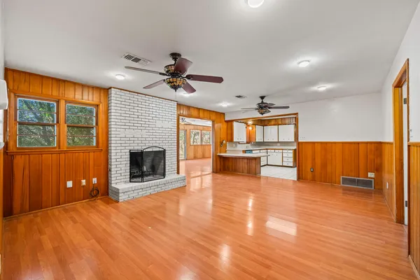 a view of a livingroom with fireplace wooden floor and a ceiling fan