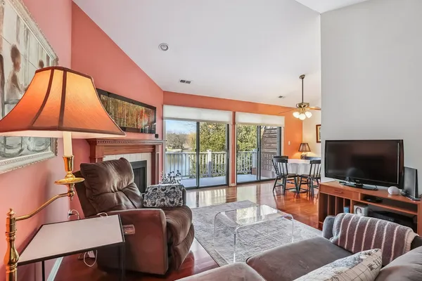 a living room with furniture a flat screen tv and a floor to ceiling window
