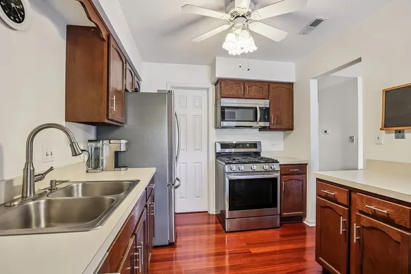 a kitchen with stainless steel appliances granite countertop a sink a stove and a refrigerator