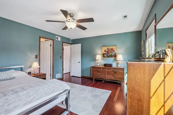 a bedroom with a bed and wooden floor