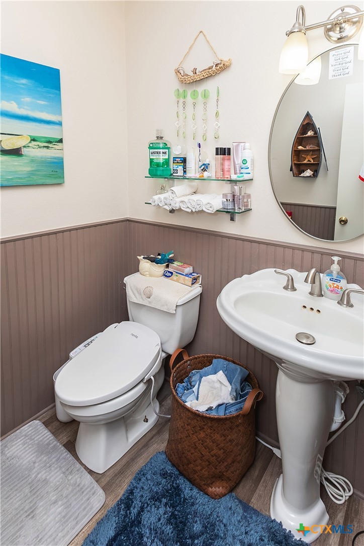 802 Bay Street Austwell, TX 77950 - Photo 20 of 27 a bathroom with a toilet a sink and a mirror