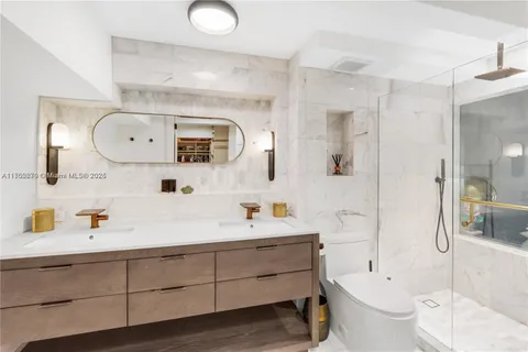 a bathroom with a toilet a sink a tub and a mirror
