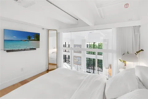 a bedroom with a large bed and a flat tv screen