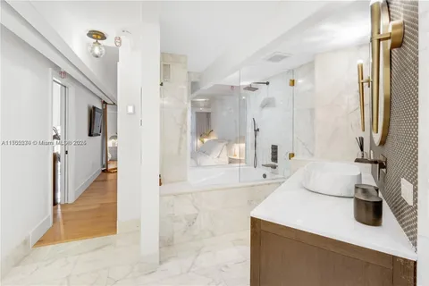 a bathroom with a tub sink and mirror