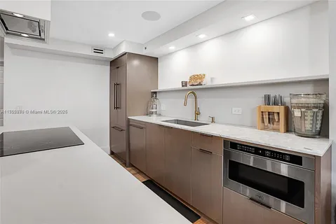 a kitchen with kitchen island a sink stainless steel appliances and cabinets