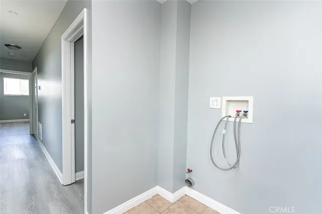 a view of a hallway with wooden floor and mirror