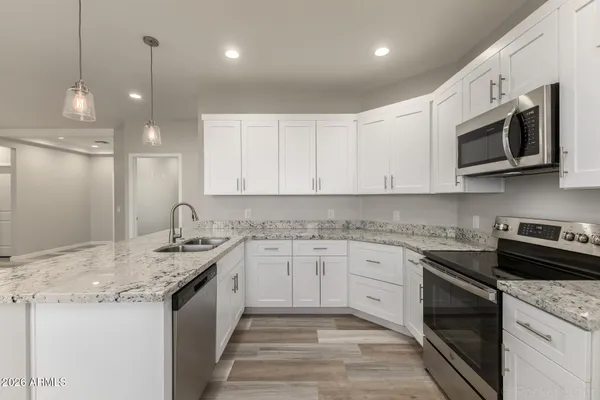 a kitchen with stainless steel appliances granite countertop a sink a stove microwave and cabinets