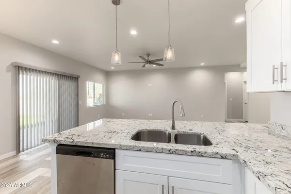a kitchen with a sink a center island a stove cabinets and wooden floor