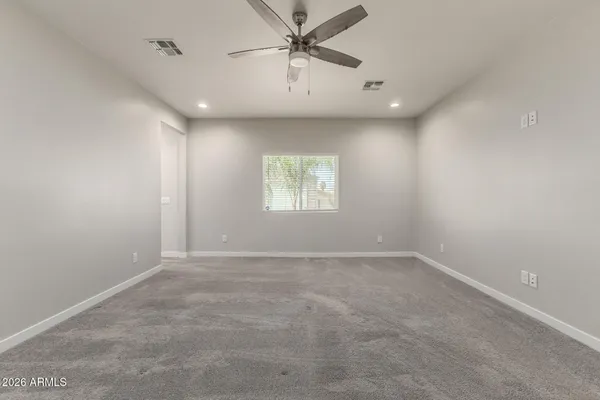 an empty room with windows and fan
