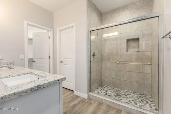 a bathroom with a granite countertop sink a toilet and shower