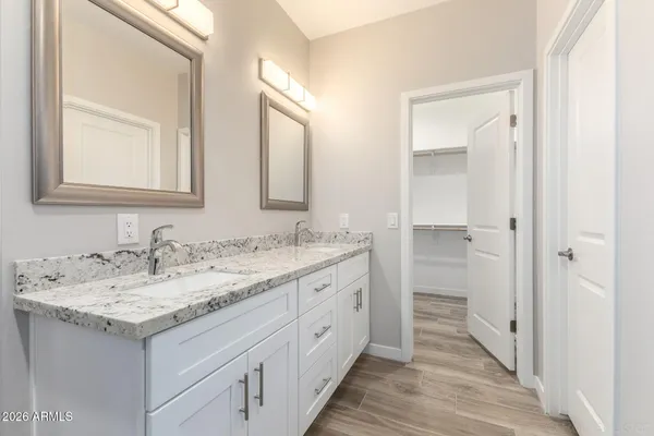 a bathroom with a granite countertop double vanity sink and a mirror