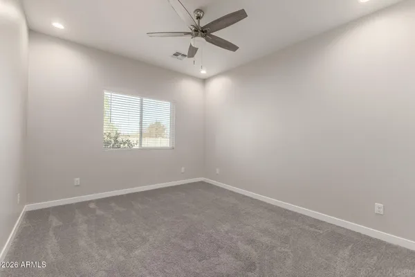 an empty room with a window and a fan