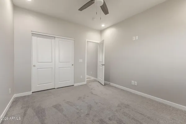 an empty room with chandelier fan