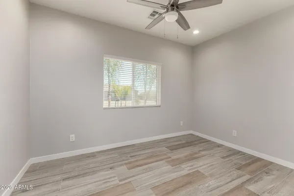 an empty room with a window and a ceiling fan