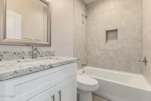 a bathroom with a granite countertop sink toilet and bathtub
