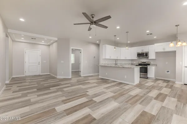 a view of kitchen with granite countertop cabinets and refrigerator