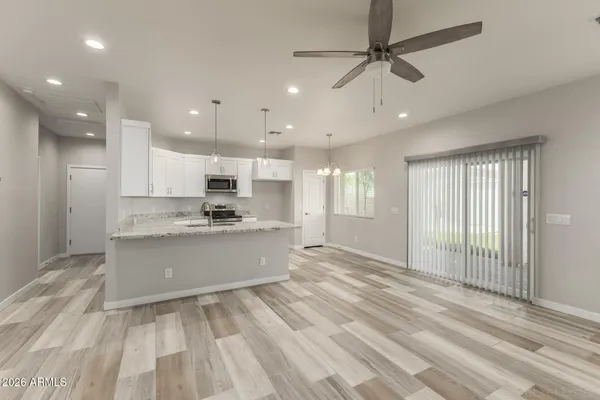 a large white kitchen with kitchen island a sink stainless steel appliances and cabinets