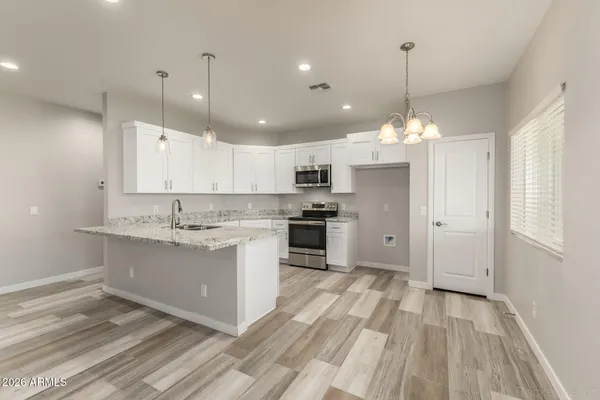 a large kitchen with granite countertop a stove oven and white cabinets