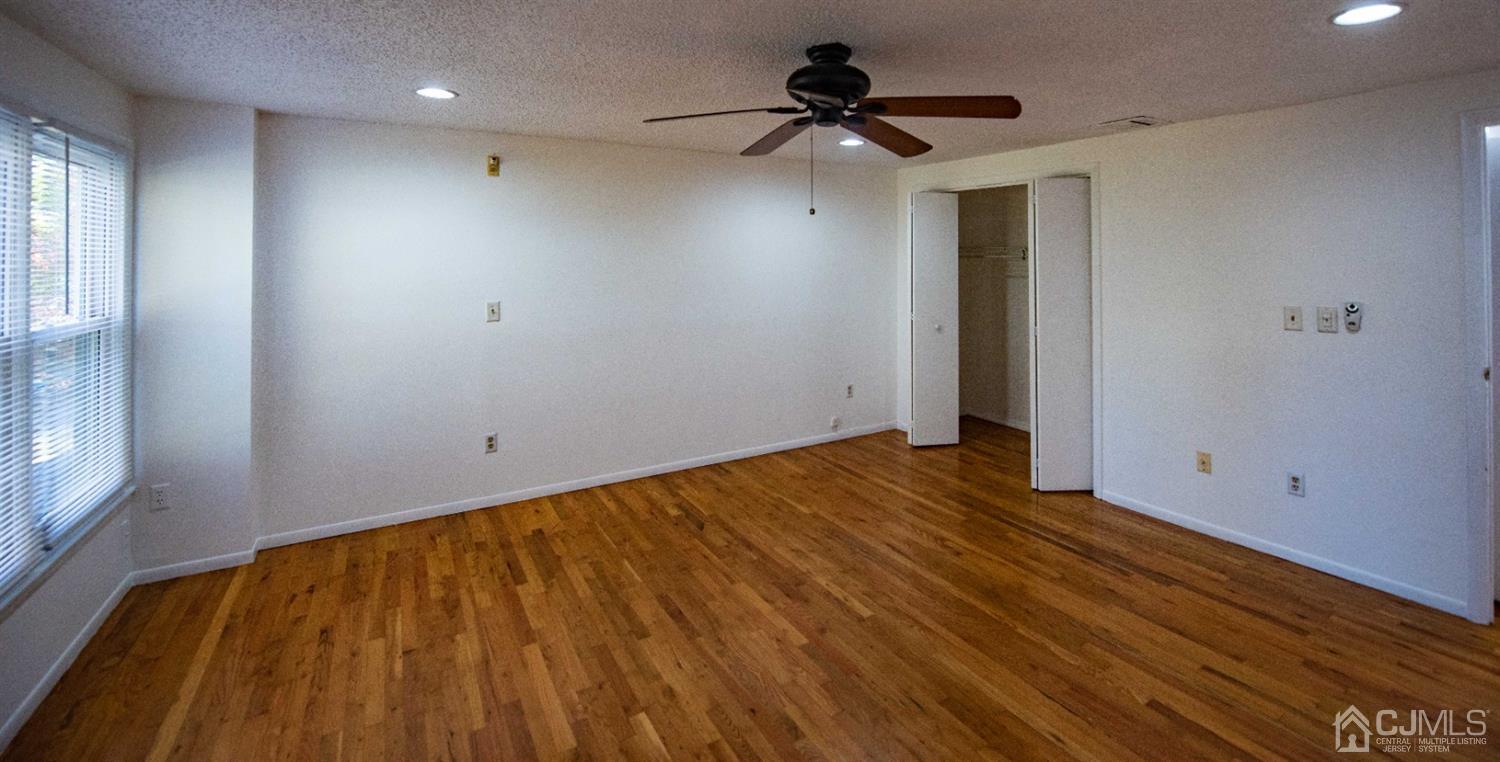 4507 Hana Road Edison, NJ 08817 - Photo 11 of 15 a view of empty room with wooden floor and fan