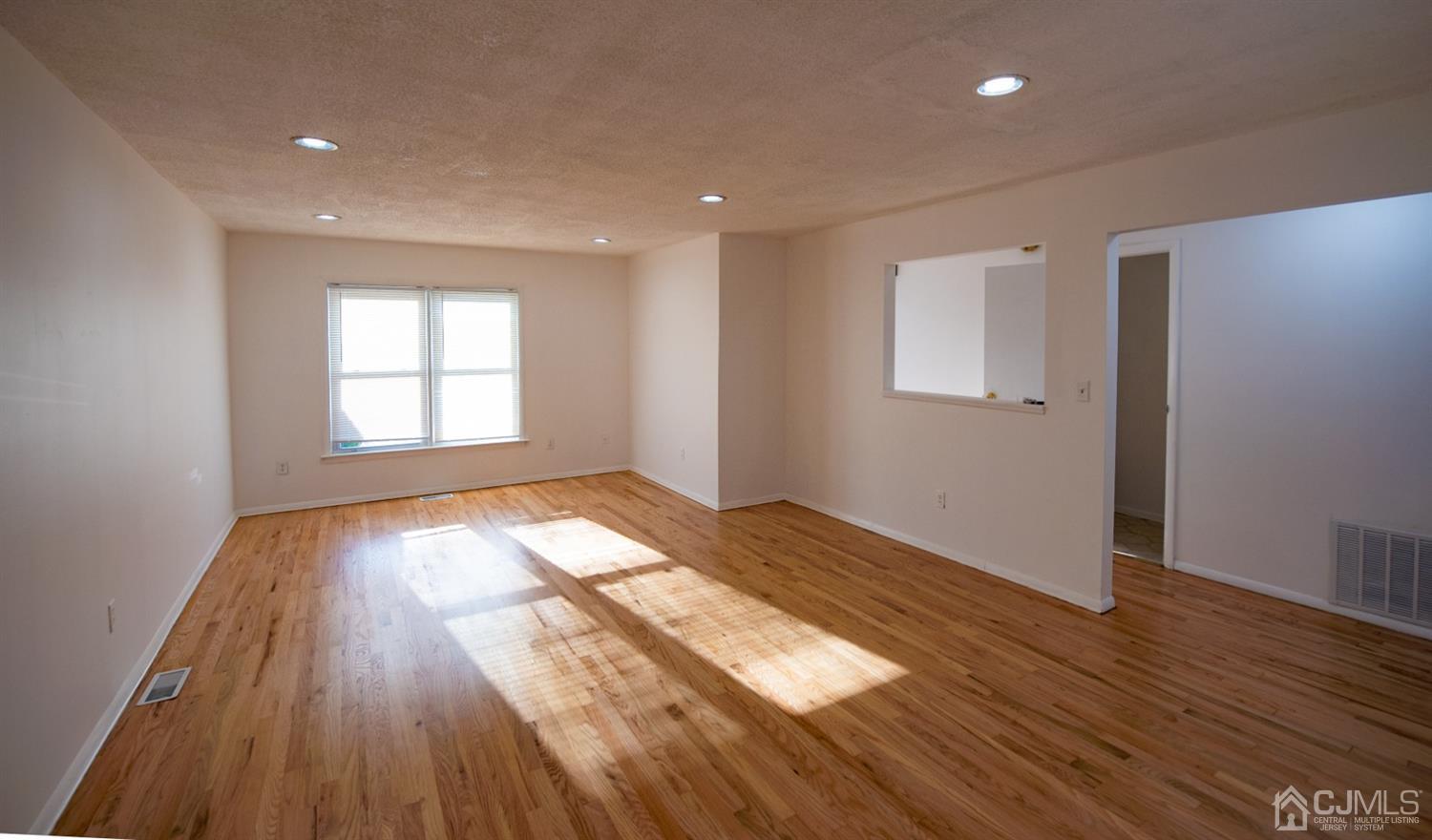 4507 Hana Road Edison, NJ 08817 - Photo 3 of 15 a view of empty room with wooden floor and fan