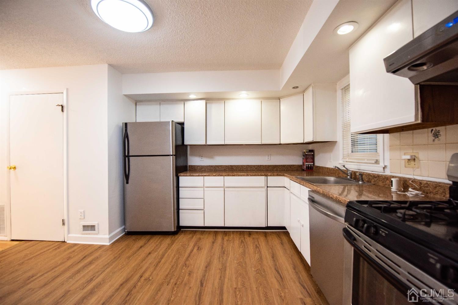 4507 Hana Road Edison, NJ 08817 - Photo 5 of 15 a kitchen with a refrigerator a sink and wooden floor