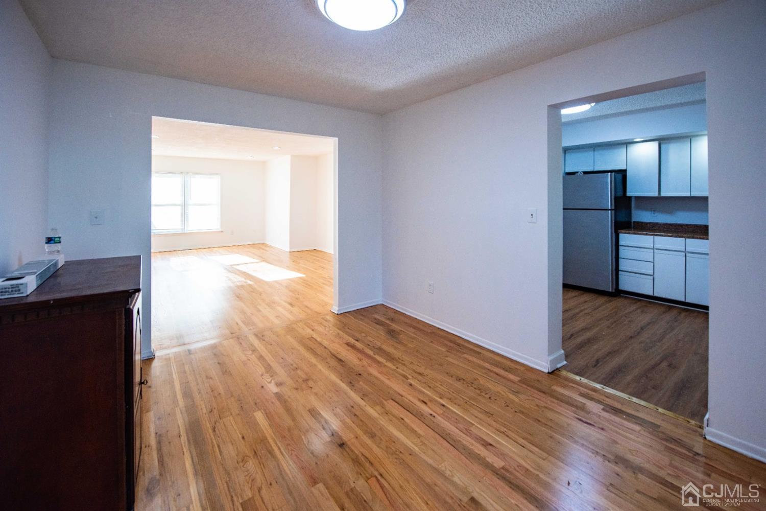 4507 Hana Road Edison, NJ 08817 - Photo 7 of 15 a view of empty room with wooden floor and kitchen
