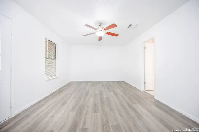 a view of empty room with wooden floor