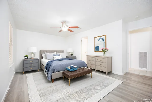 an empty room with wooden floor and fan