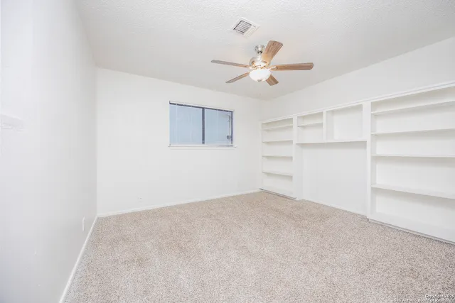 a bedroom with a bed potted plant on the dresser and a window