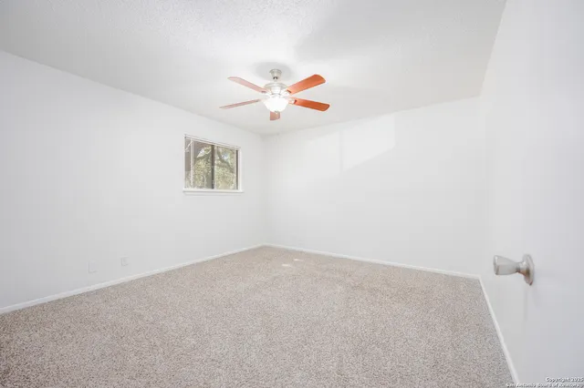 a bedroom with a bed and a lamp on dresser