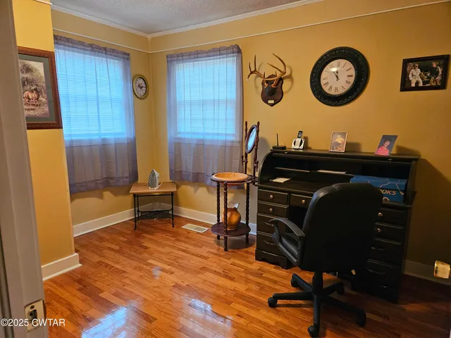 a view of a workspace with furniture and wooden floor