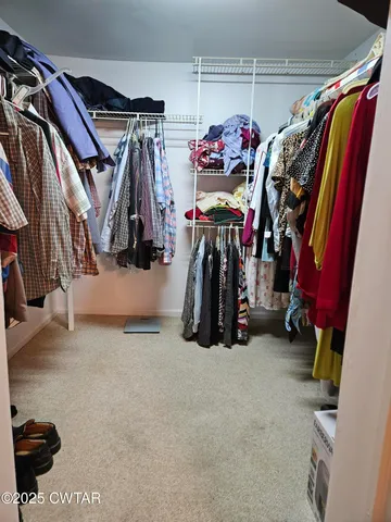 a view of walk in closet with clothes